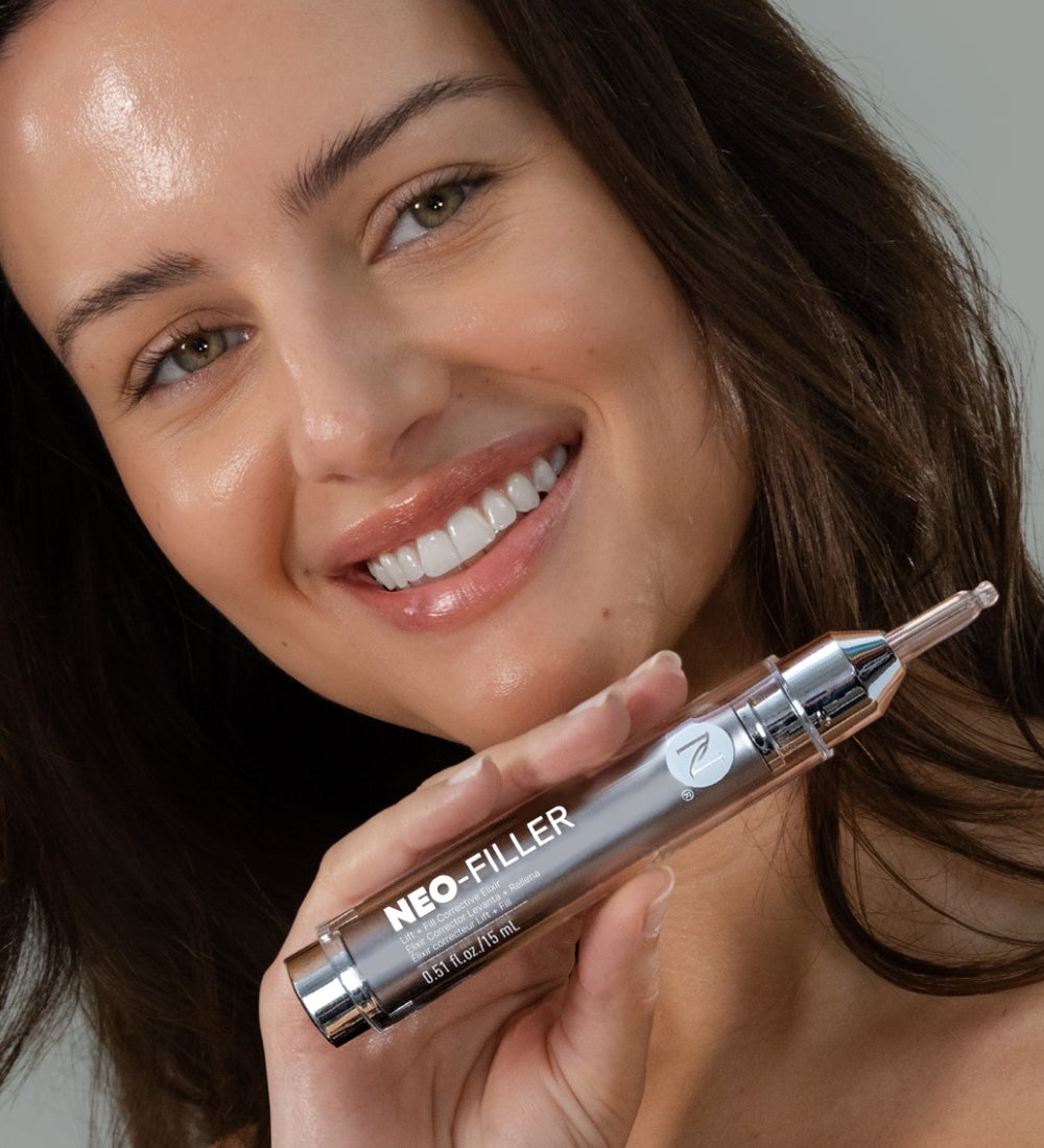 A woman holding a tube of Neo-FILLER under her chin.